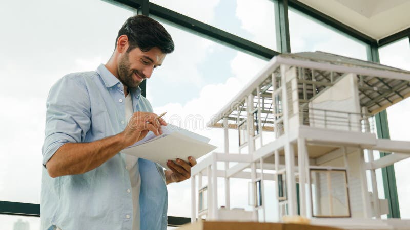 Professional architect comparing between blueprint house model. Tracery royalty free stock image