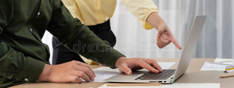 Arhitectul profesionist a editat planul prin utilizarea laptopului. închidere. delinizare. Arhitectul profesionist a editat planul prin utilizarea laptopului, în timp ce managerul de proiect punctează punctul greșit în sala de întâlnire de pe masa de întâlnire cu documentul arhitectural împrăștiat în jurul.