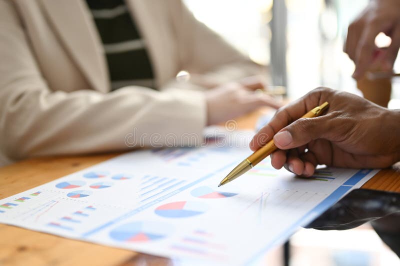 Professional Asian male financial analyst pointing his pen on financial report. cropped shot stock photo