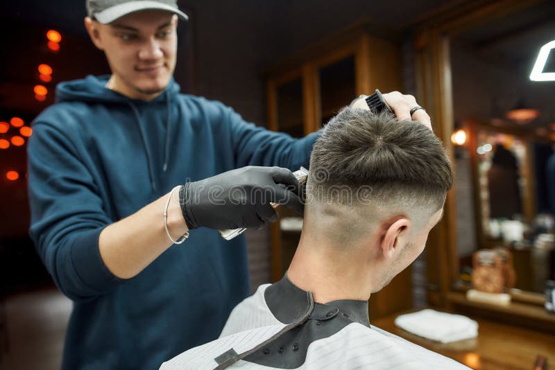 Professional Barber Working with Hair Clipper, Making Modern Haircut for a Young Man Sitting in Barbershop Chair. Focus Stock Photo - Image of hairstyle, grooming: 191664006 Professional Barber Working with Hair Clipper, Making Modern Haircut for a Young Man Sitting in Barbershop Chair. Focus Stock Photo - Image of hairstyle, grooming: 191664006