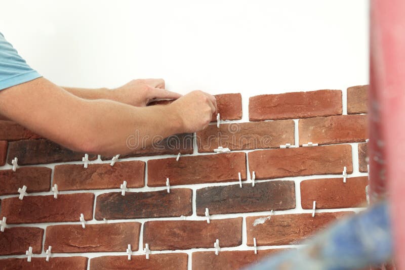 Professional Builder Gluing Decorative Brick on Wall, Closeup. Tiles