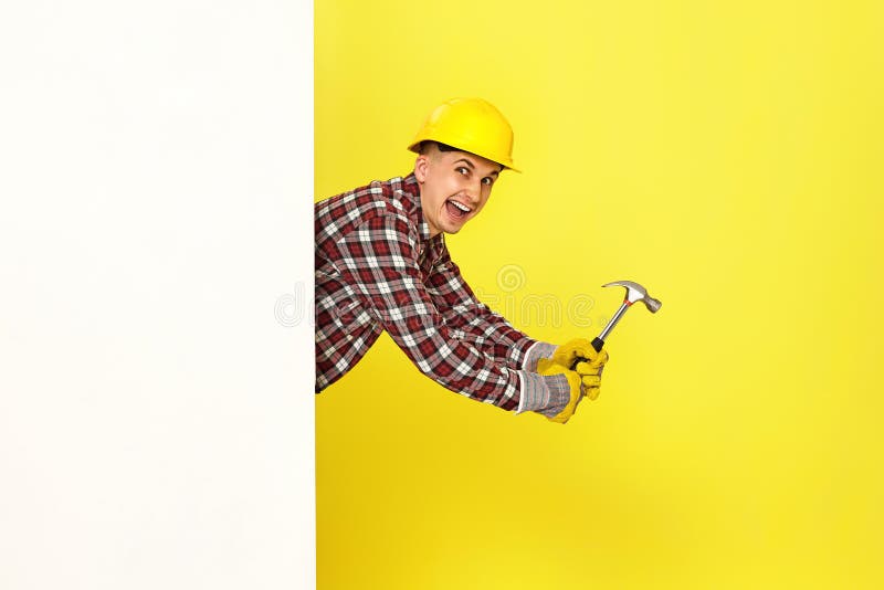 professional builder in work clothes in helmet holding hammer. royalty free stock photos