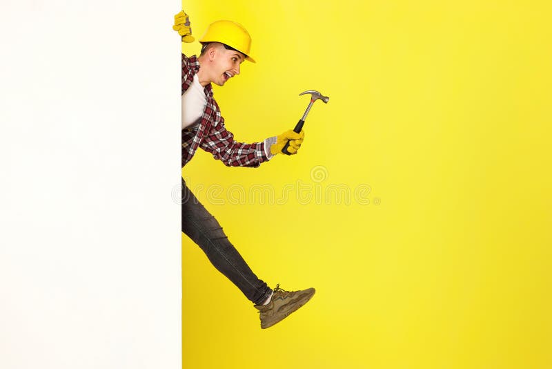 professional builder in work clothes in helmet holding hammer. stock photography