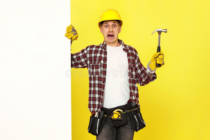 professional builder in work clothes in helmet holding hammer. stock photography