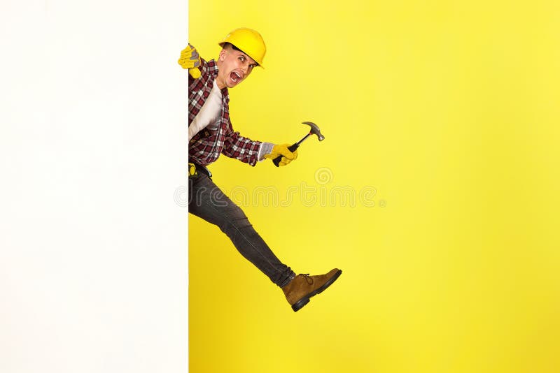 professional builder in work clothes in helmet holding hammer. stock photos