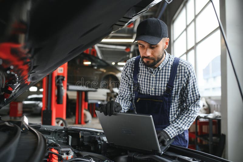 Professional Car Mechanic Working in Auto Repair Service. Stock Photo