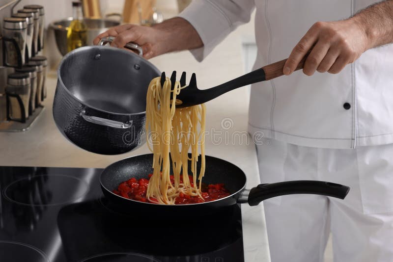 Professional Chef Cooking Delicious Pasta on Stove in Kitchen, Closeup