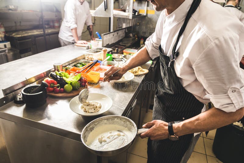 Professional Chef Cooking In The Kitchen Restaurant At The Hotel