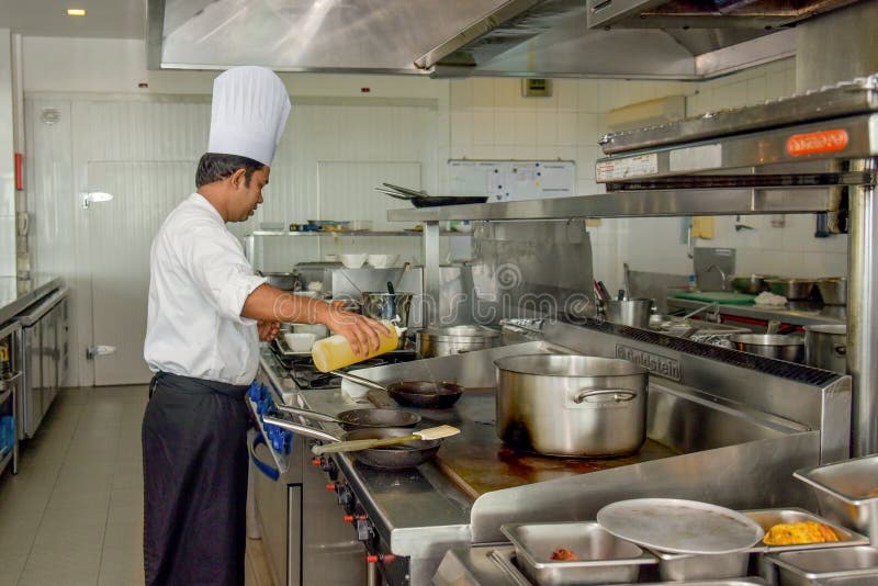 Professional Chef Putting Oil on the Skillet at the Kitchen Editorial