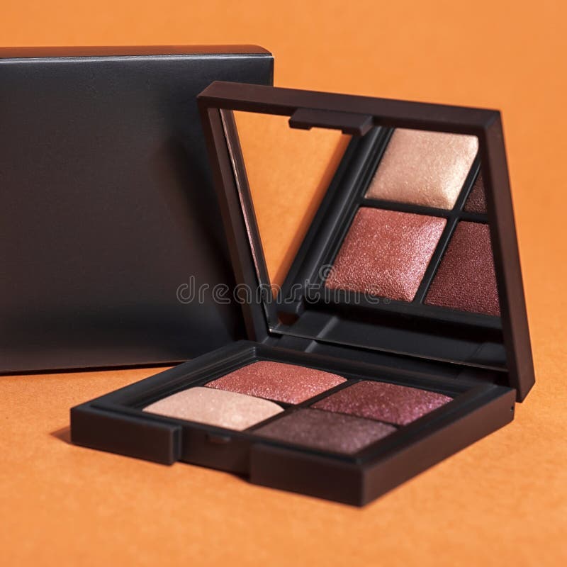 Professional colorful eye shadows for make up in plastic box on orange background. Mock up image with space for text royalty free stock photos