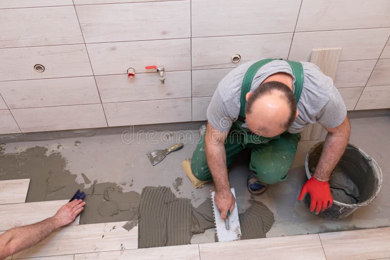 Free Photo  Builder checks the quality of the laid tiles with a manual  bubble level construction worker installing ceramic floor tiles on  construction sites floor repair selective focus
