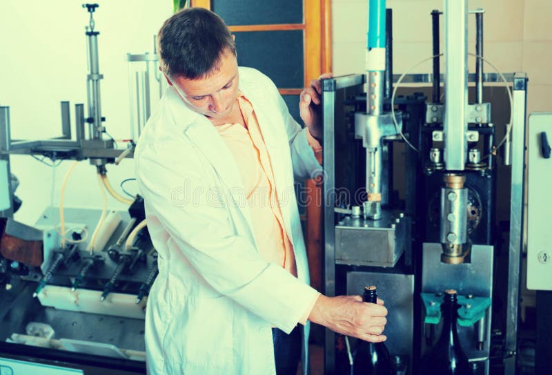 Professional conveyor worker checking quality of bottles royalty free stock photos Professional conveyor worker checking quality of bottles royalty free stock photos