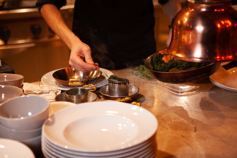 Professional Cook. Chef in Black Apron and Cap Working in Restaurant