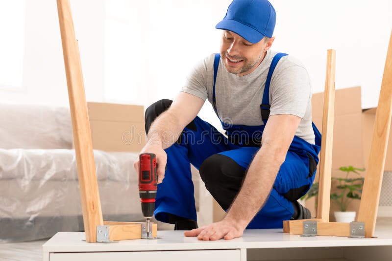 Professional Craftsman Carpenter Assembling Table Using Electric Drill Working Indoor stock photography