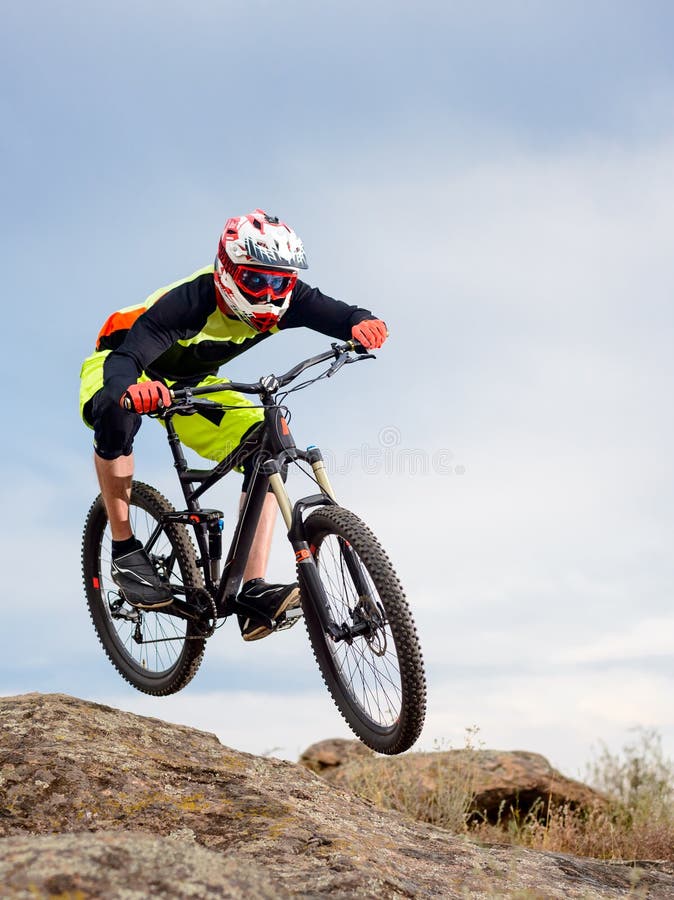 Professional Cyclist Riding the Bike Down Rocky Hill. Extreme Sport Concept. stock image Professional Cyclist Riding the Bike Down Rocky Hill. Extreme Sport Concept. stock image