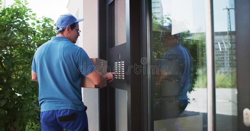 Professional Delivery Man Using Intercom To Enter Building royalty free stock images