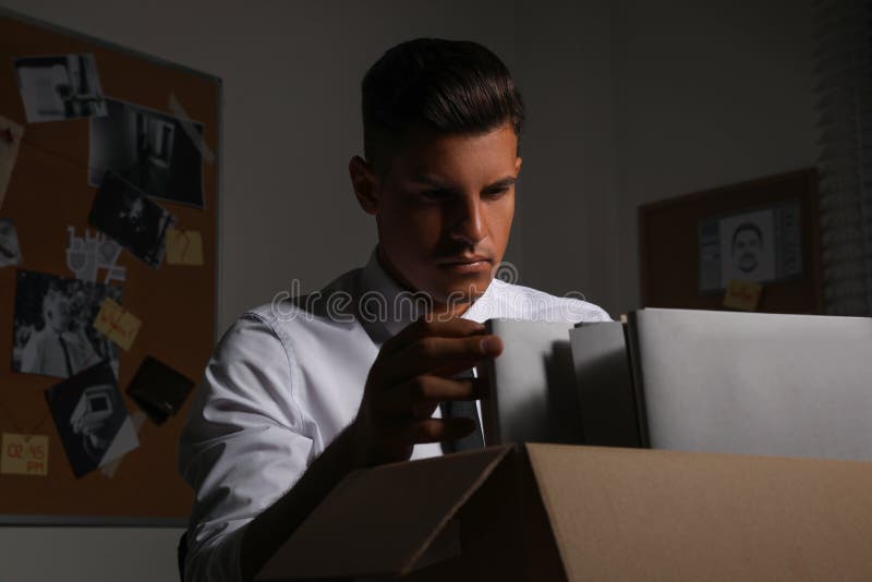 Professional detective doing paperwork in his office. Detective paperwork stock images, royalty-free photos and pictures