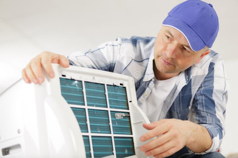 Professional Electrician Man Fixing Heavy Air Conditioner Stock Image