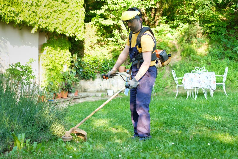 Professional gardener using an edge trimmer in home garden royalty free stock photos