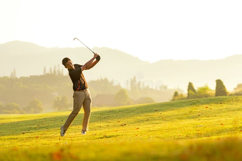 Professional Golfer asian man swing and hitting golf ball practice at golf driving range and fairway in sunny morning day on club