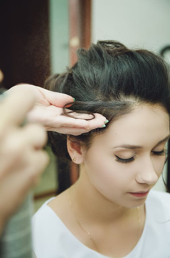 A professional hairdresser makes a festive hairstyle for the girl. Close-up royalty free stock image A professional hairdresser makes a festive hairstyle for the girl. Close-up royalty free stock image