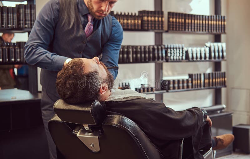 Professional hairdresser modeling beard with scissors and comb at the barbershop. stock image Professional hairdresser modeling beard with scissors and comb at the barbershop. stock image