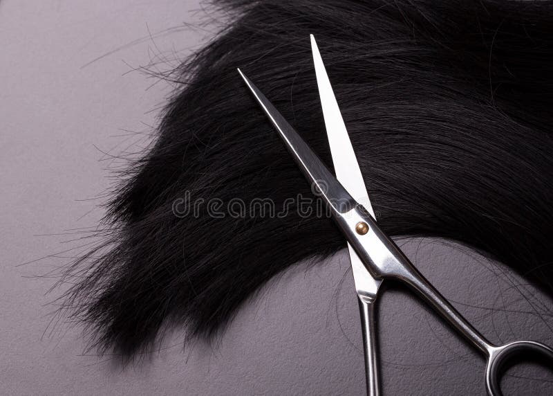 Professional hairdresser scissors lying on natural black hair stock photos Professional hairdresser scissors lying on natural black hair stock photos