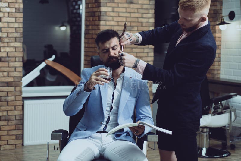 Professional hairstylist in barbershop interior. Male client getting haircut by hairdresser. Balm on dry body parts to royalty free stock image Professional hairstylist in barbershop interior. Male client getting haircut by hairdresser. Balm on dry body parts to royalty free stock image