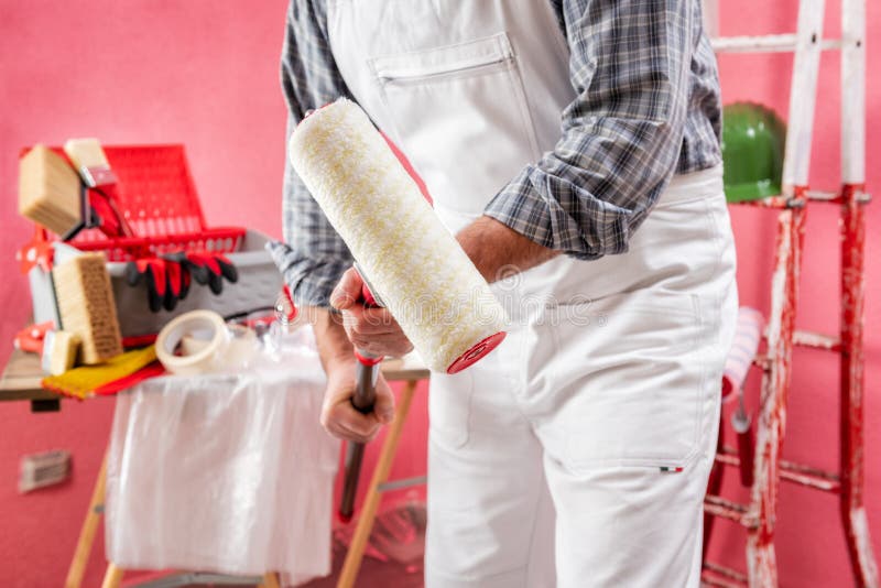 Professional House Painter at Work on the Construction Site Stock Photo