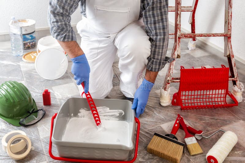 Professional House Painter at Work Prepares the Wall Paint Stock Photo