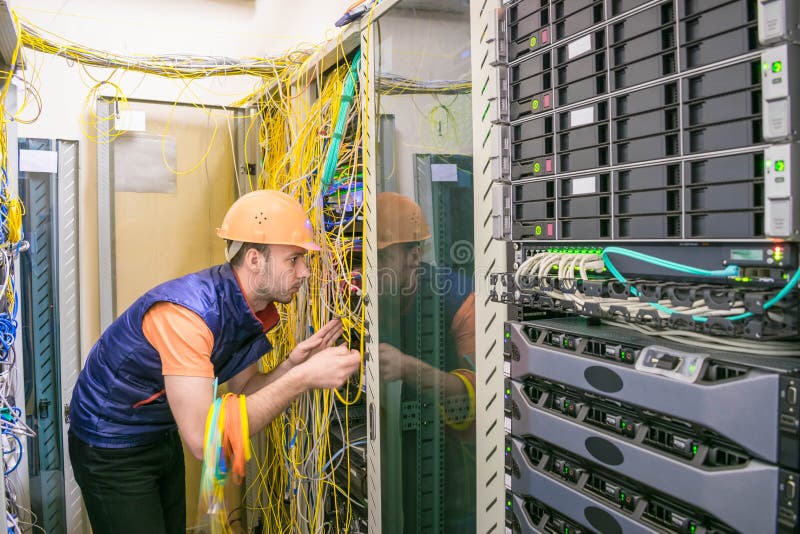 Professional internet campaign worker serves a rack with a central route. Engineer works with computer switching equipment. stock photography