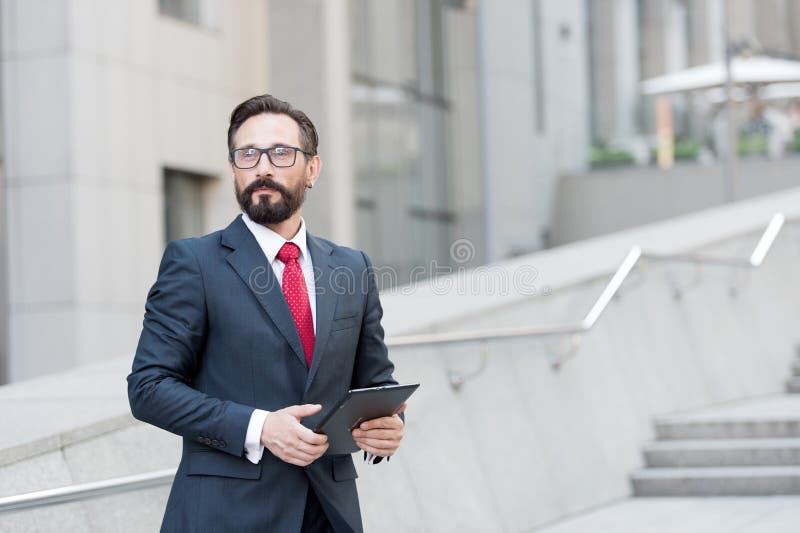 Professional manager looking away with a tablet in hands stock image Professional manager looking away with a tablet in hands stock image