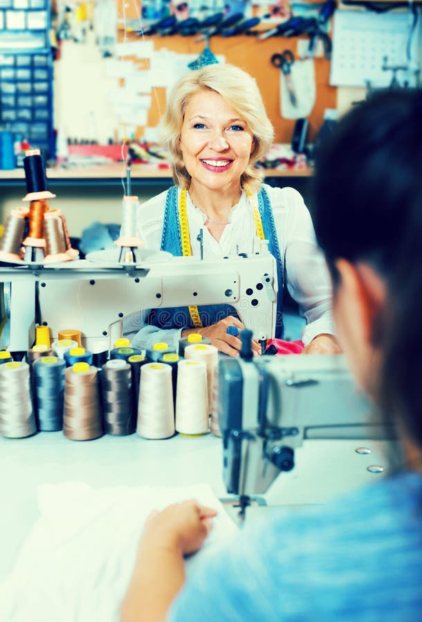 Professional Mature Woman Tailor Using Sewing Machine Stock Image