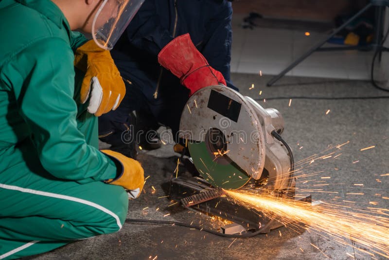 Professional Mechanic Man is Cutting Steel Metal with Rotating Carbon