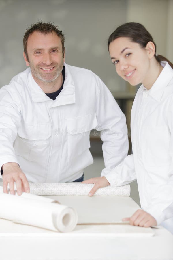 Professional Painters with Jumpsuits Cutting Paper Rolls Stock Image