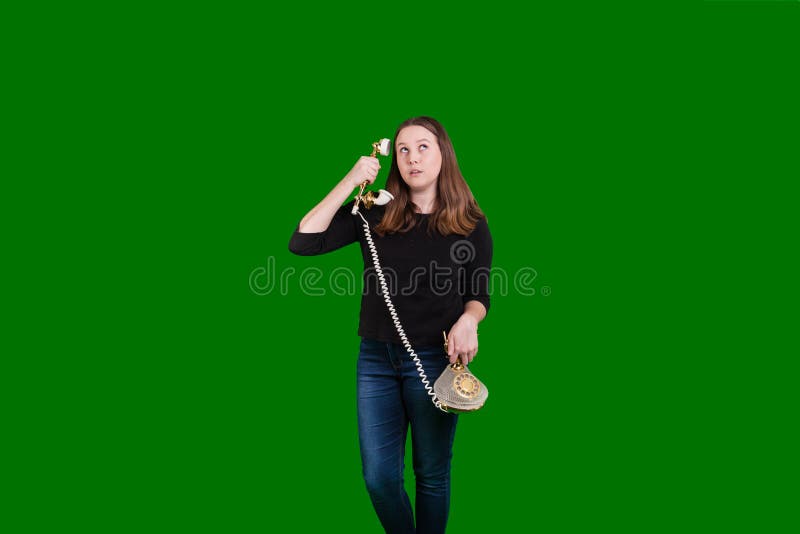 Old vintage corded telephone held by young women phone receiver held to her ear stock photo Old vintage corded telephone held by young women phone receiver held to her ear stock photo