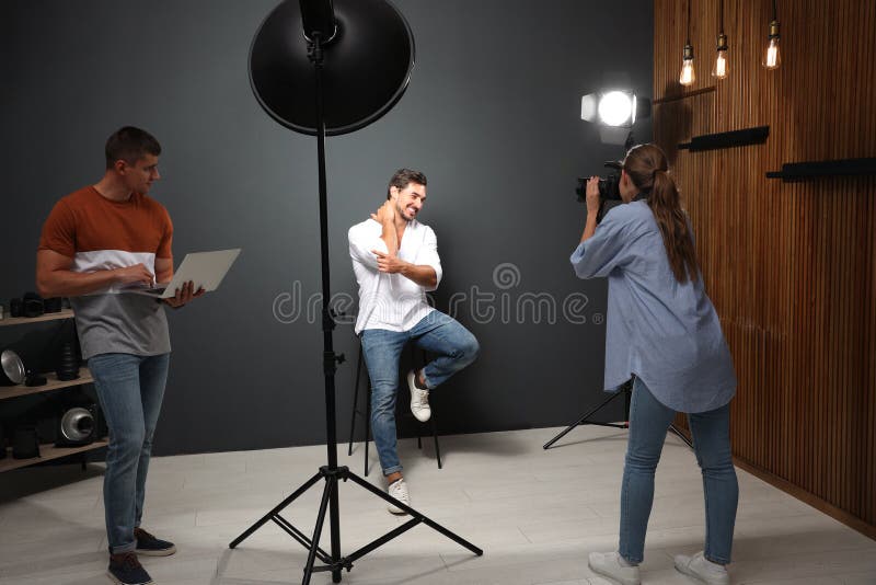 Professional Photographer with Taking Picture of Young Man in Modern