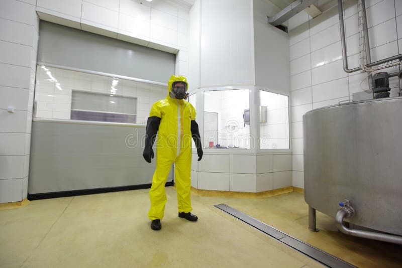 Professional in protective suit in plant stock photo