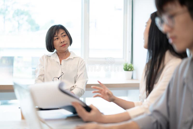 Un șef profesionist asiatic senior este în întâlnire cu echipa ei royalty free stock image