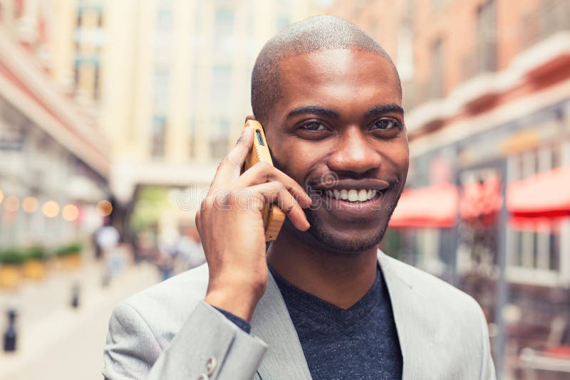 Portrait young urban professional smiling man using smart phone talking on mobile outside outdoors