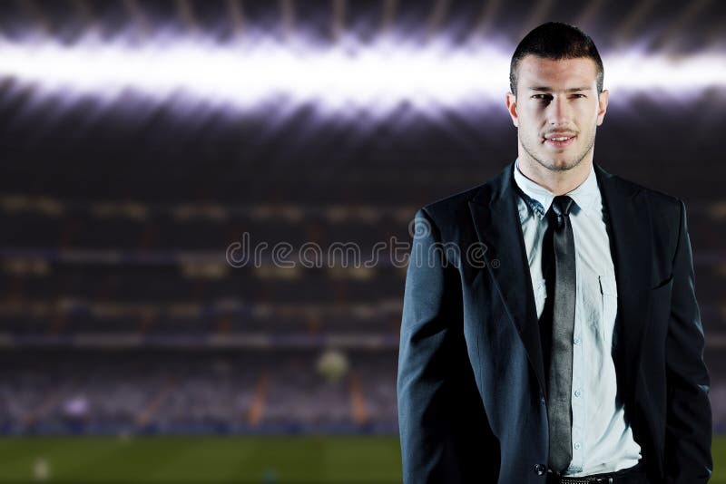 Soccer sport manager in business suit coach and football player on stadium with green grass and white ball. Soccer sport manager in business suit coach and football player on stadium with green grass and white ball