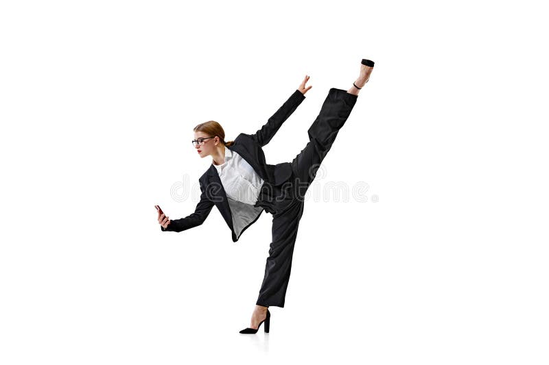 Professional in suit demonstrates remarkable flexibility with high kick and checking news in phone against white royalty free stock photo