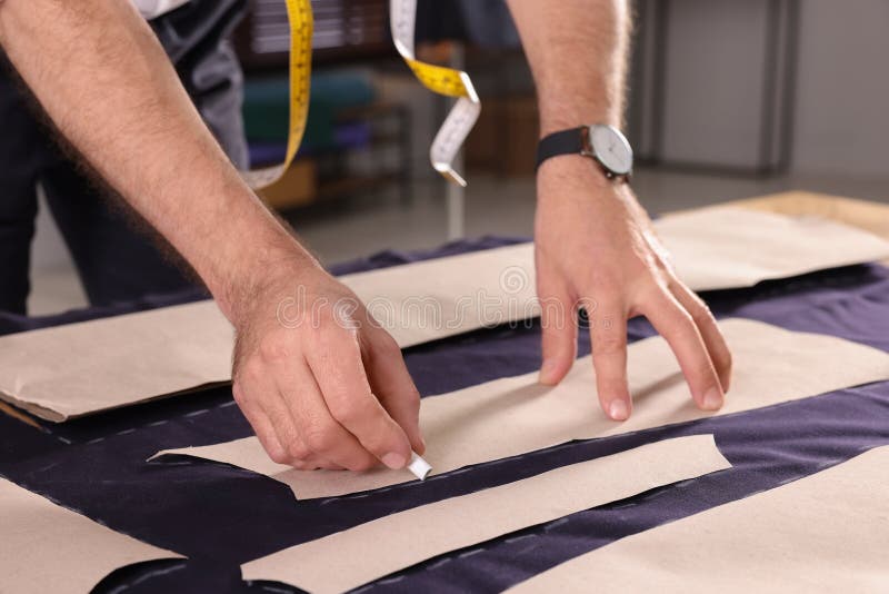 Professional Tailor Marking Sewing Pattern on Fabric with Chalk at