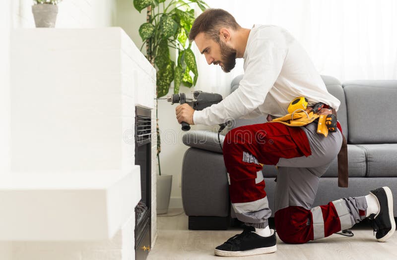 Professional Technician with Screwdriver Installing Electric Fireplace