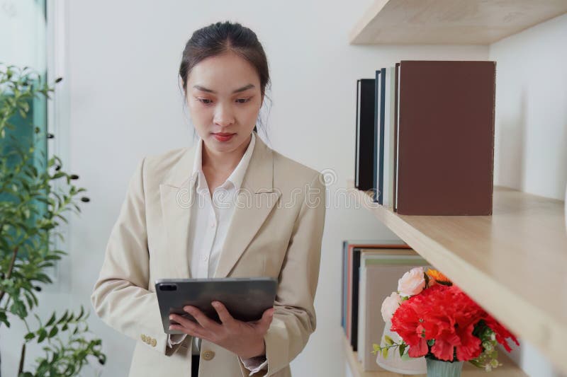A professional woman engaged with a tablet, surrounded by a stylish office setting, reflecting modern work habits and technology use. Reading efficiency stock images, royalty-free photos and pictures