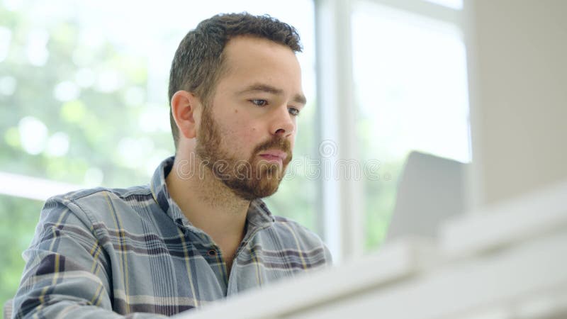 Focused employee working on laptop in modern office stock video footage