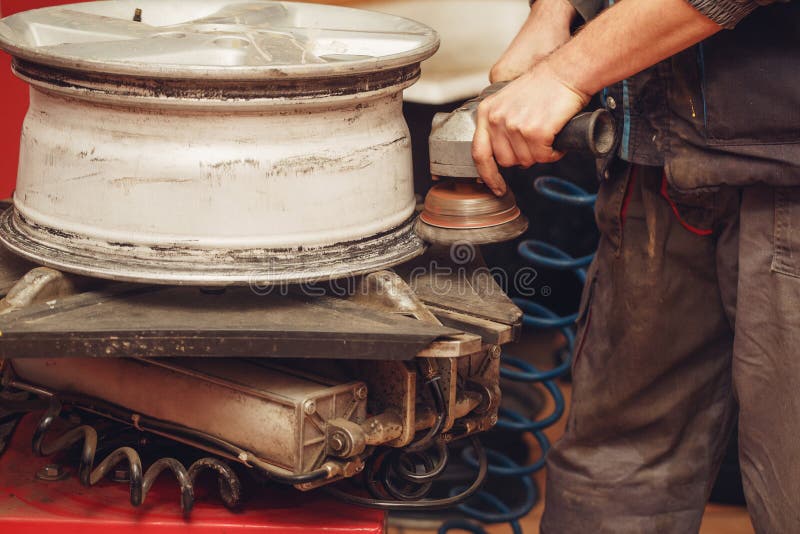 Professional Worker Using Tire Grinder Machine for Tire Wheels Stock