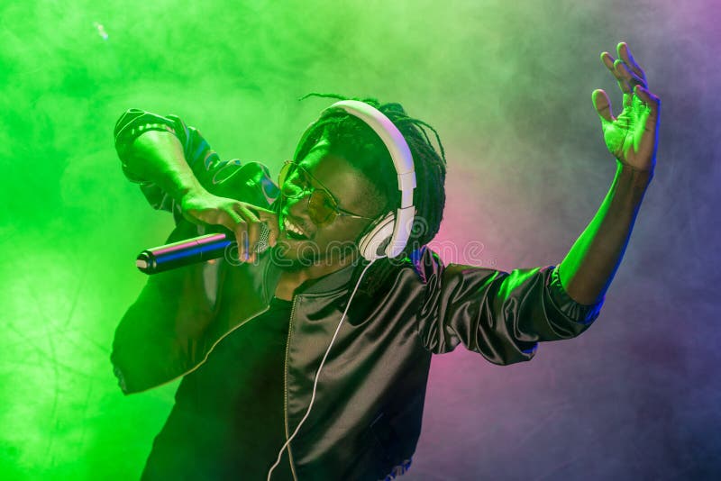 professionele Afrikaanse Amerikaanse club DJ in hoofdtelefoons die met microfoon zingen stock foto's professionele Afrikaanse Amerikaanse club DJ in hoofdtelefoons die met microfoon zingen stock foto's