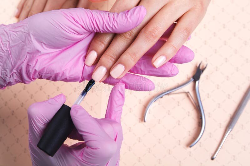 Professionele manicure die kleurrijk nagellak tonen om het afwerkingsresultaat te controleren stock afbeeldingen Professionele manicure die kleurrijk nagellak tonen om het afwerkingsresultaat te controleren stock afbeeldingen
