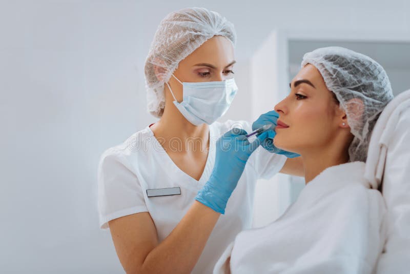 Professionele vrouwelijke cosmetologist die een schoonheidsinjectie doen stock afbeeldingen Professionele vrouwelijke cosmetologist die een schoonheidsinjectie doen stock afbeeldingen